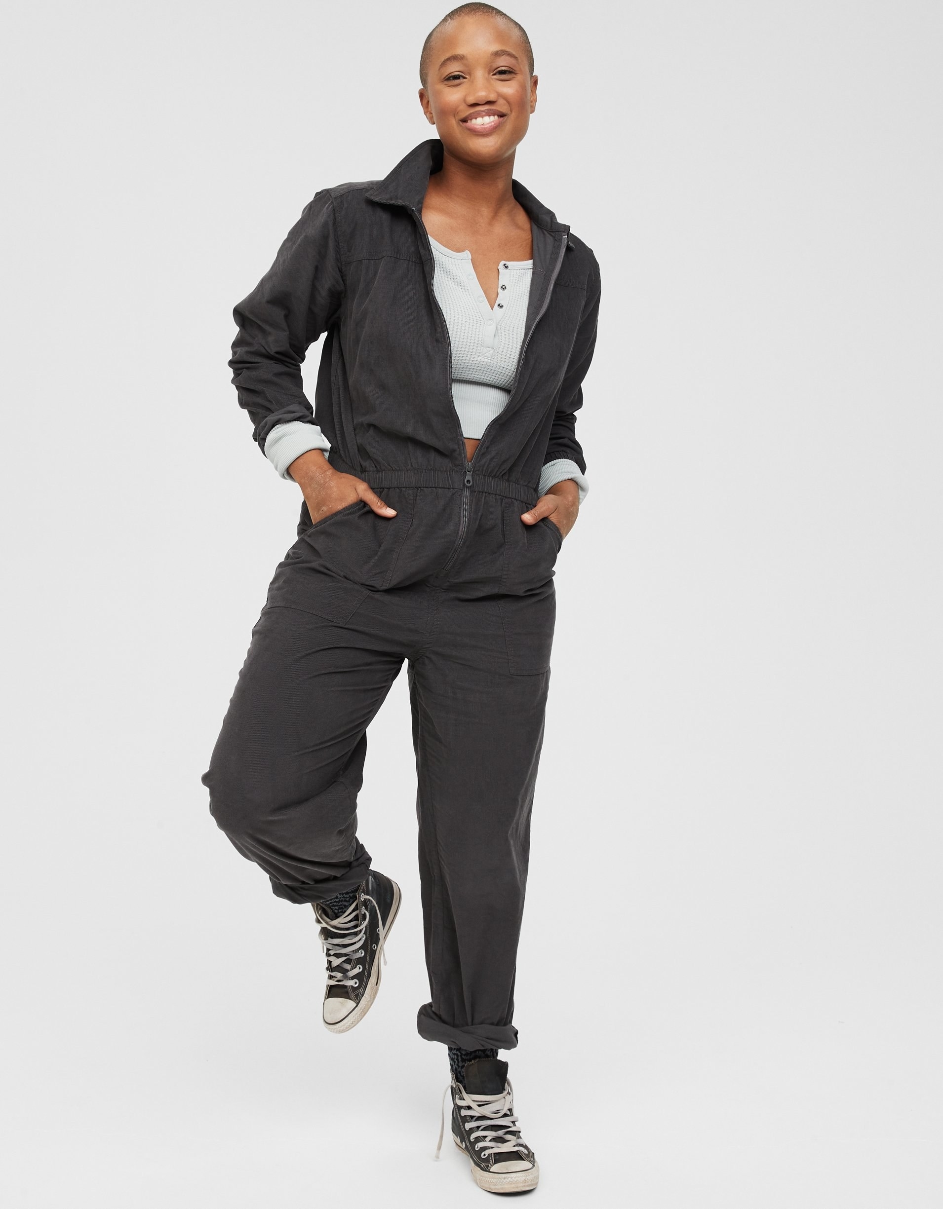 model in grey long sleeve jumpsuit with center zipper and cuffed pants