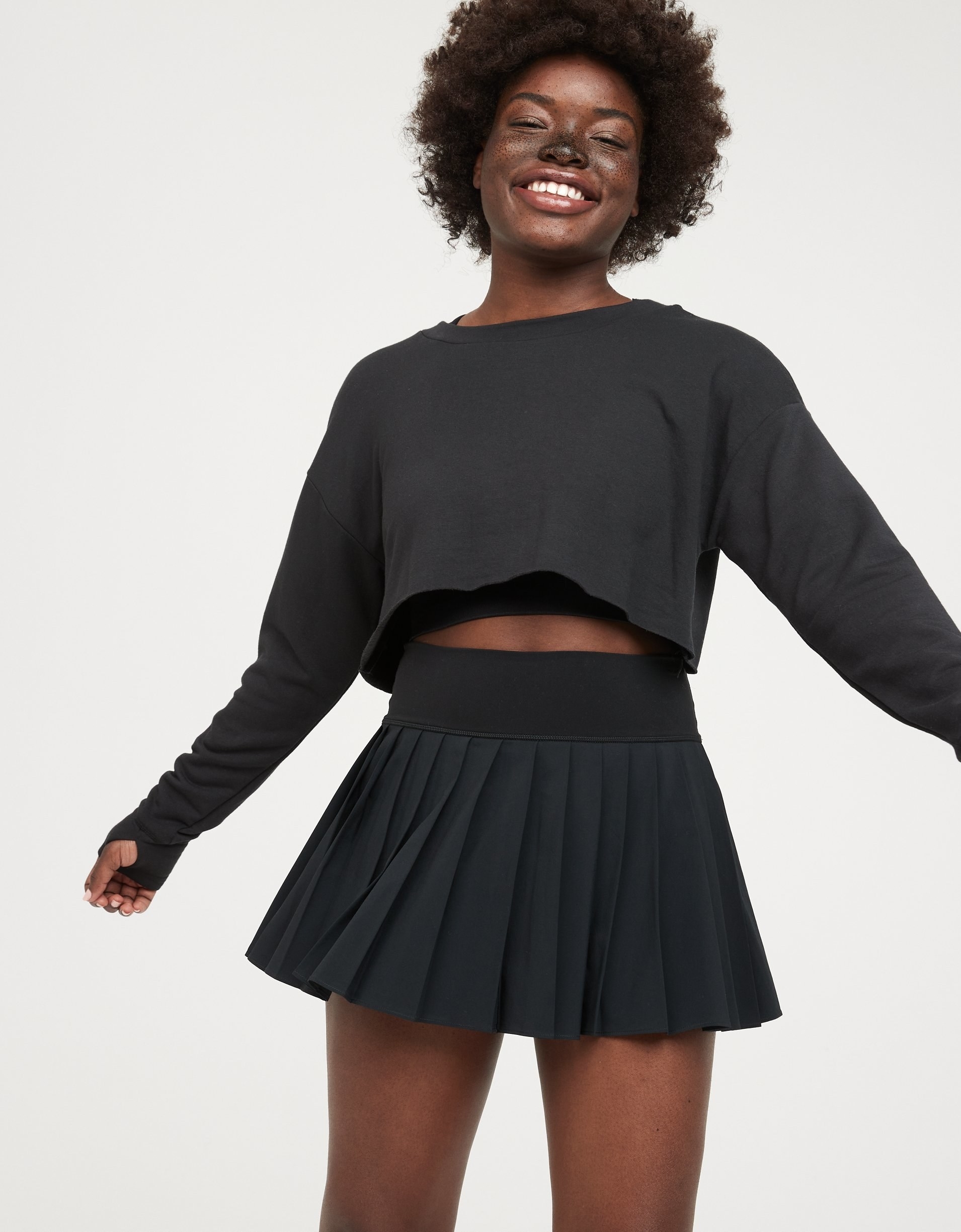 model in short black pleated tennis skirt