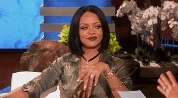 Rihanna laughing, winking, and pointing