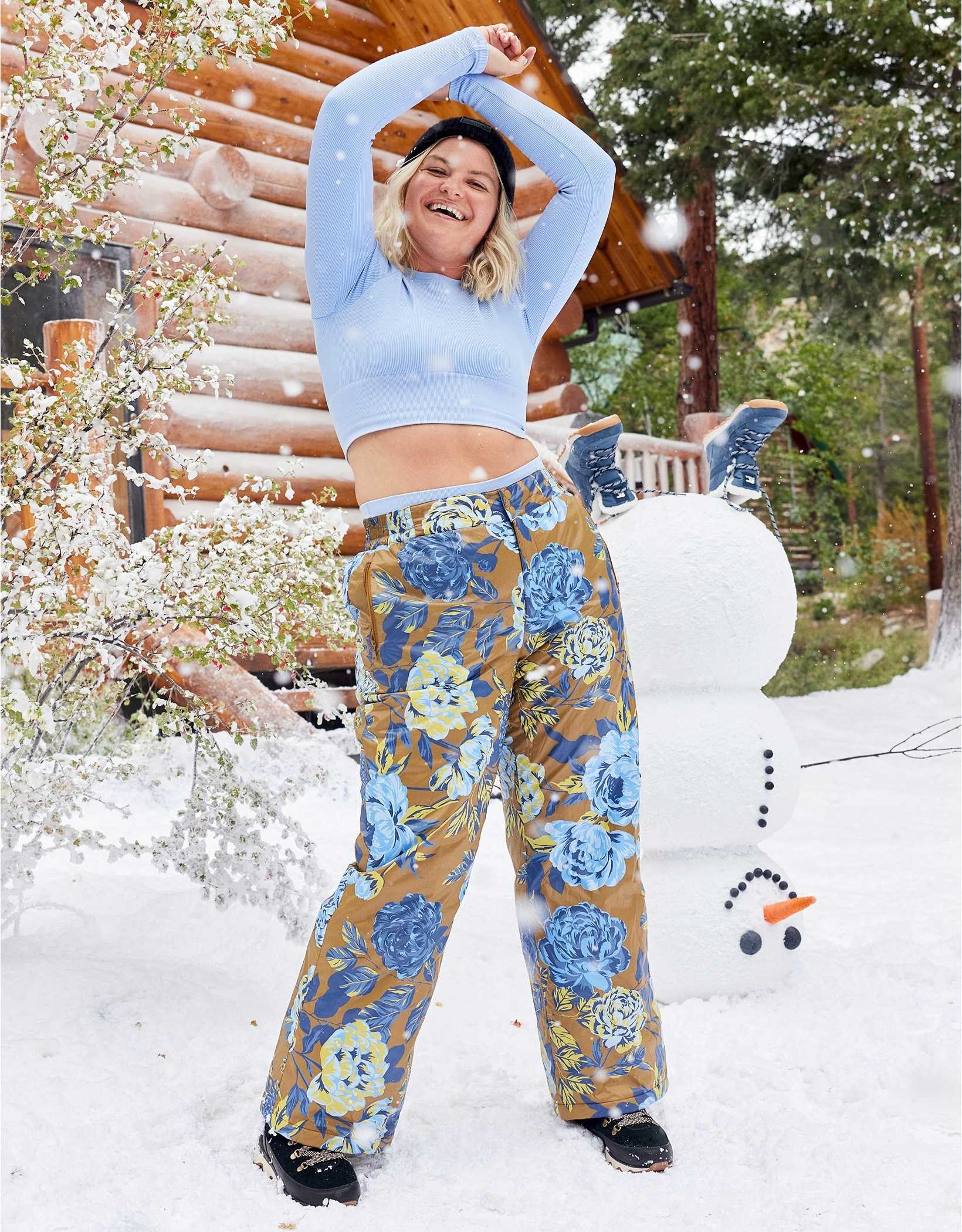 model in brown snow pants with a light and dark blue flower pattern