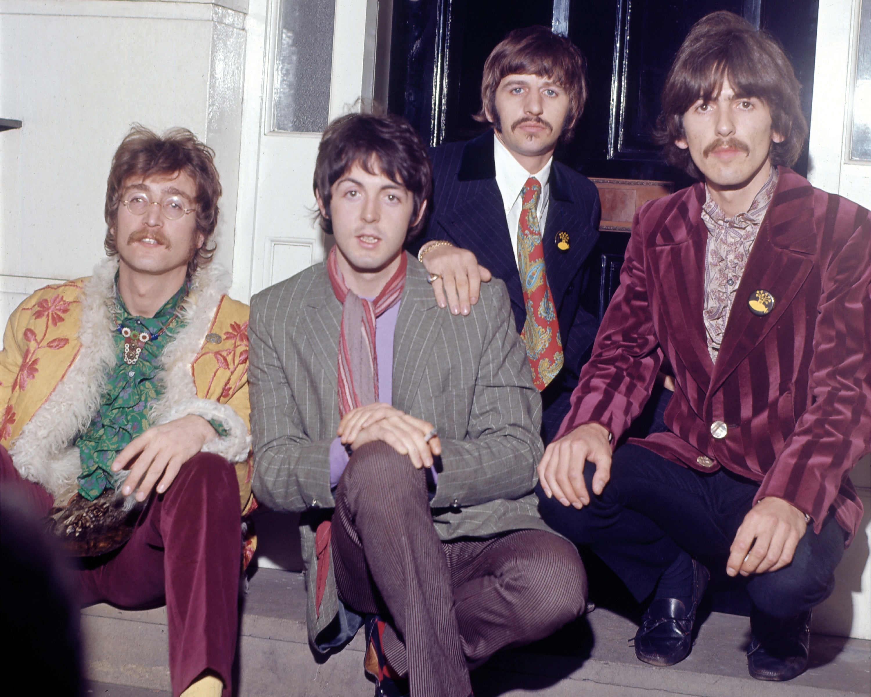 a color photo of the band sitting on a stoop