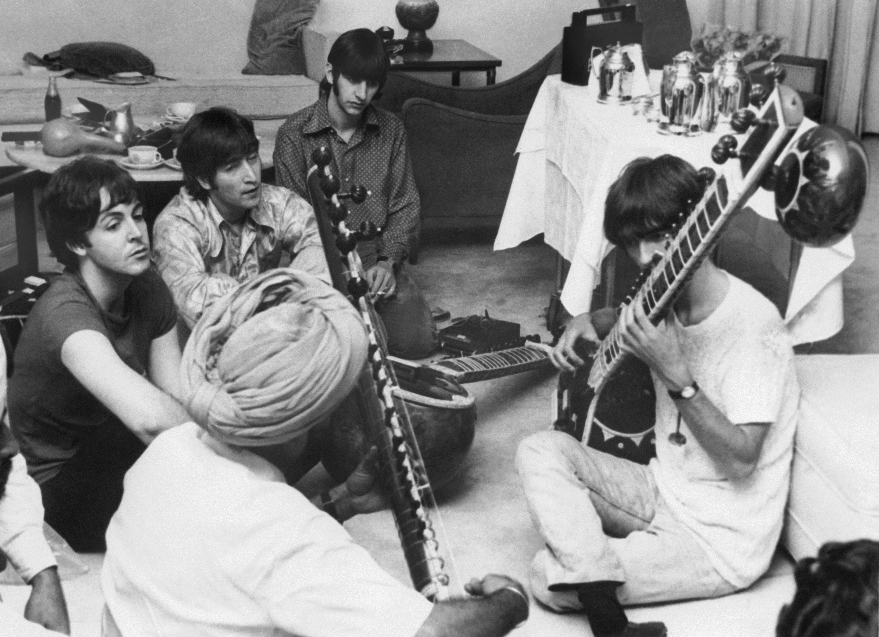 the band sits on the floor in India while learning a new instrument
