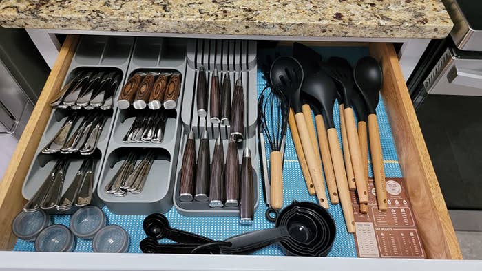 a reviewer shows an organized kitchen drawer with three gray silverware sorters