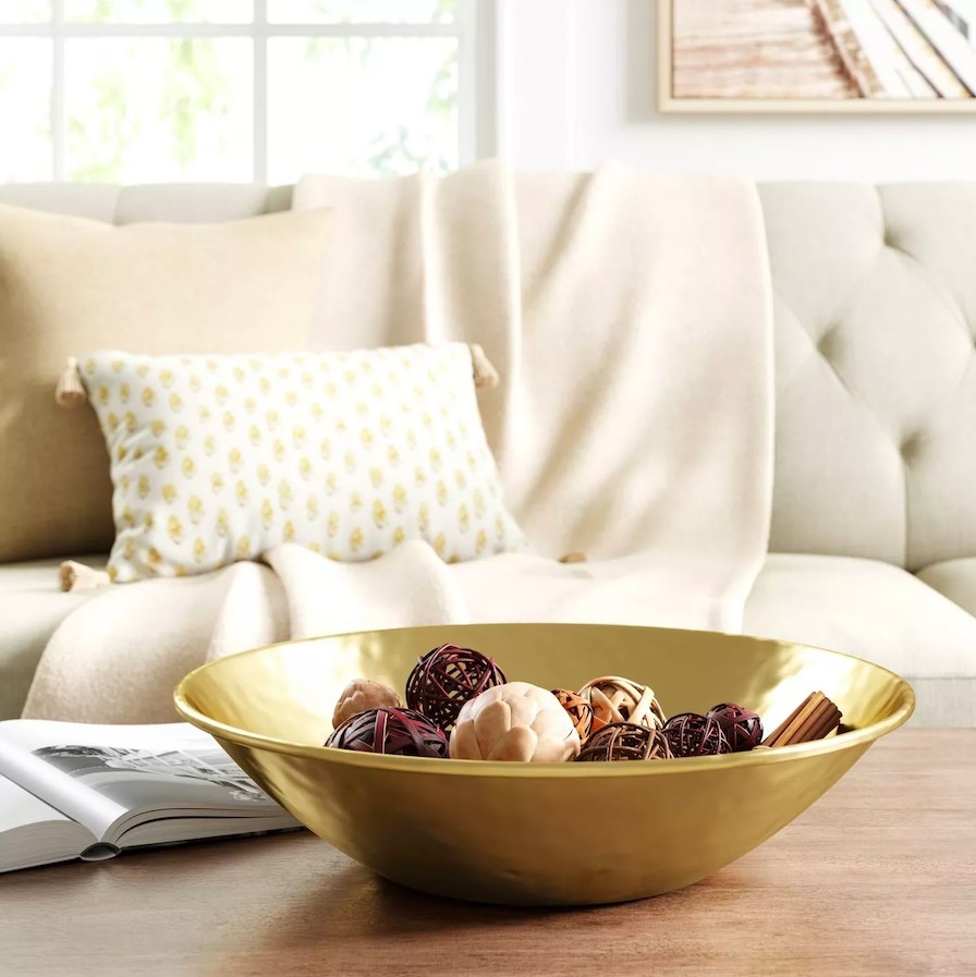 Gold bowl filled with potpourri on a coffee table