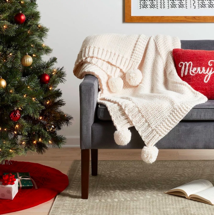 Blanket draped over a settee next to a Christmas tree