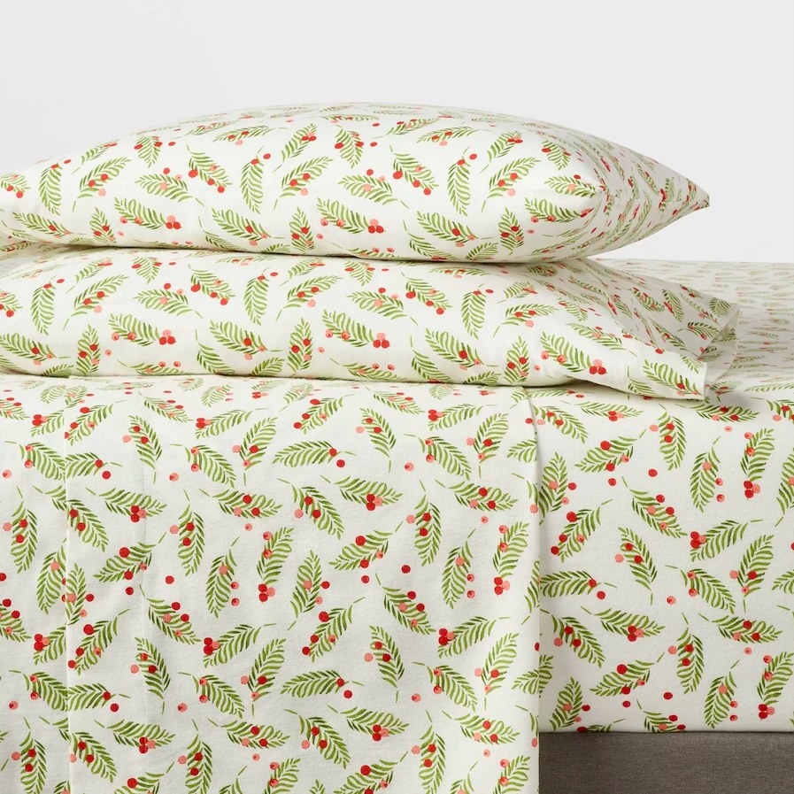 Holly patterned sheets shown on a bed