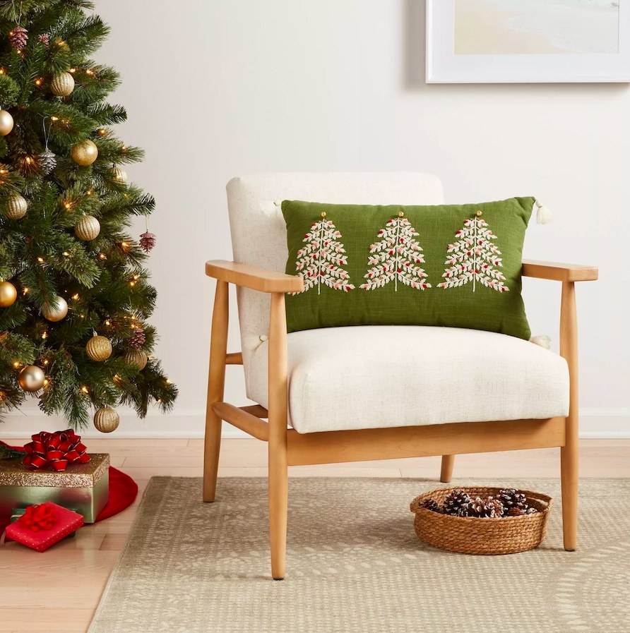 Green throw pillow on an armchair, next to a Christmas tree