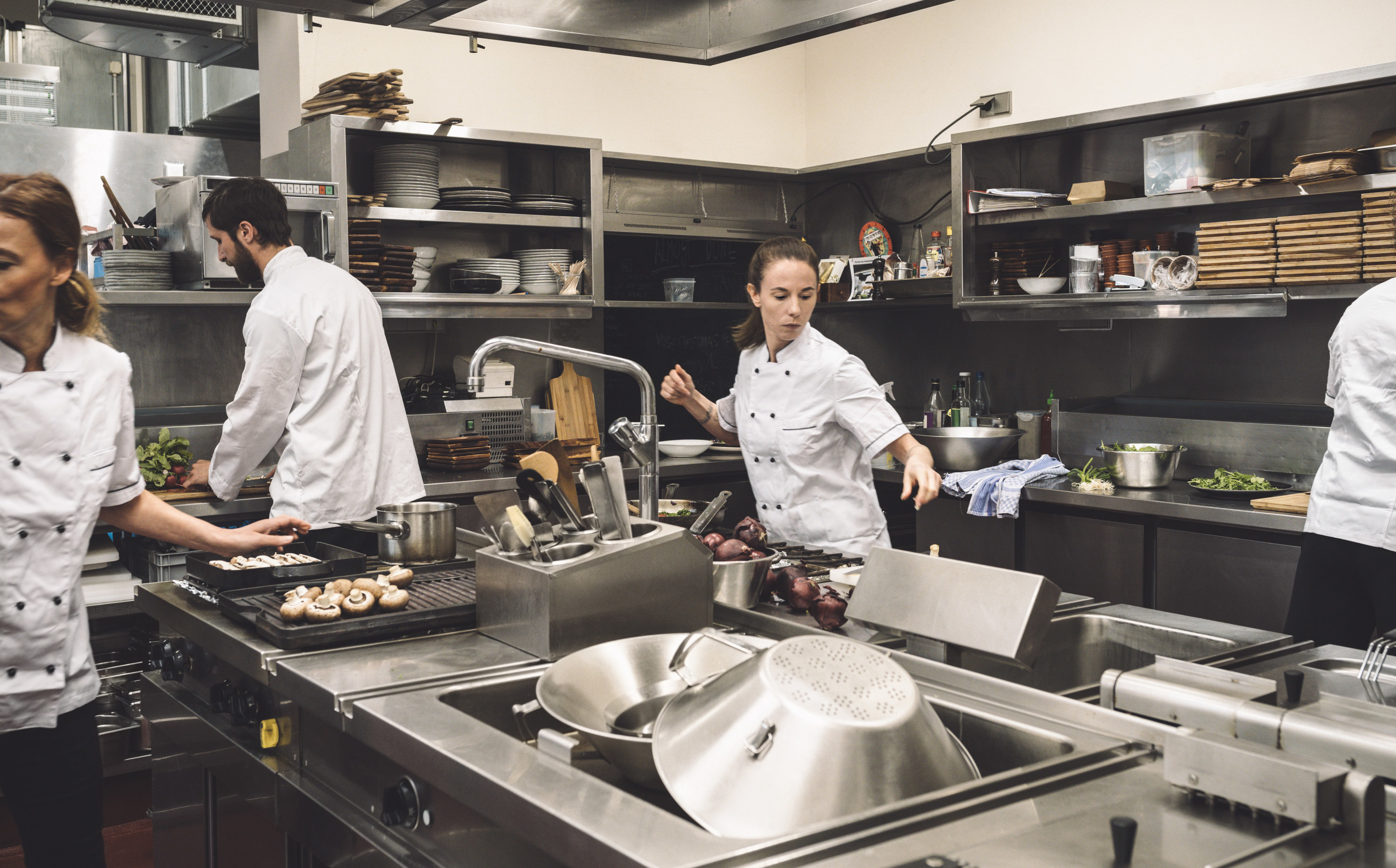 Chefs in restaurant kitchen, moving quickly and busily