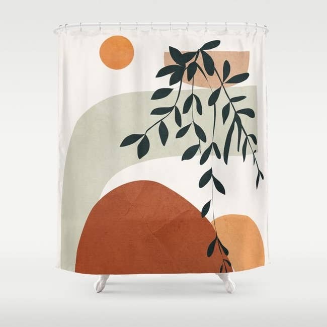 white shower curtain with colorful green, brown, and tan shapes and leaf illustration