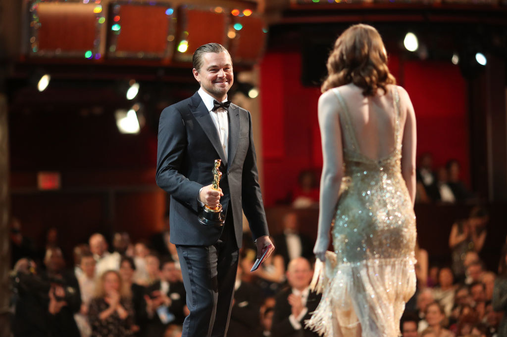 Leonardo DiCaprio presenting a trophy to Emma Stone