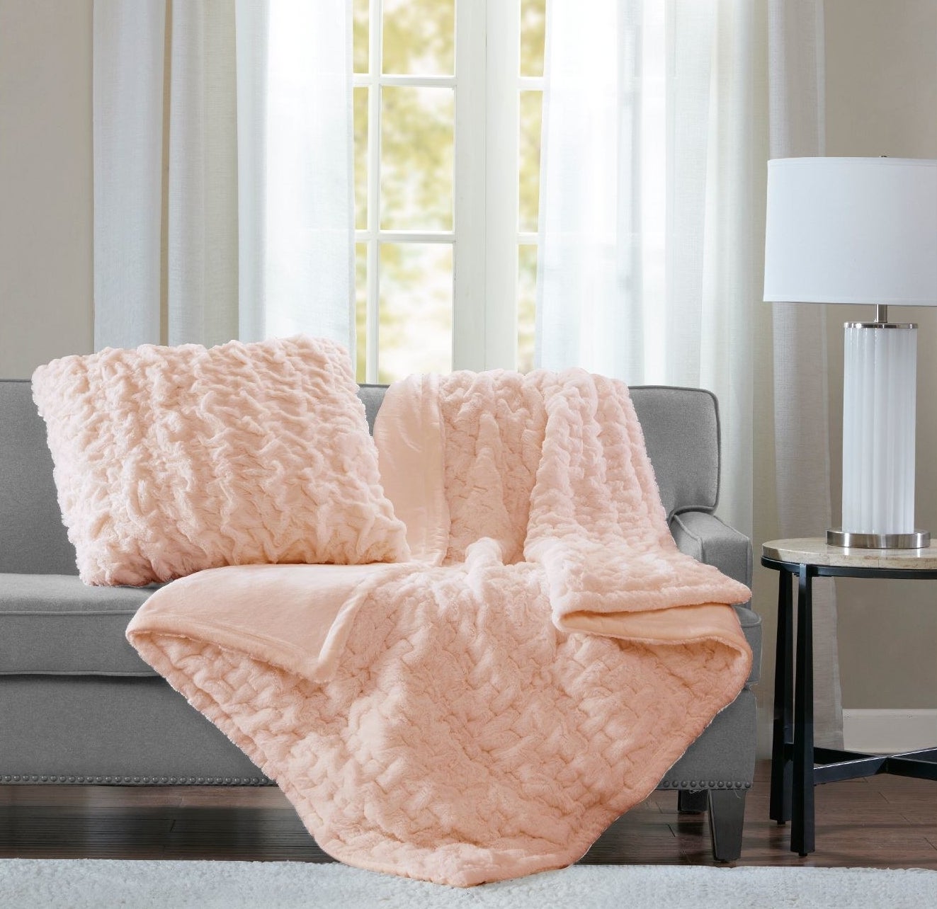 pink faux fur throw blanket draped over a couch