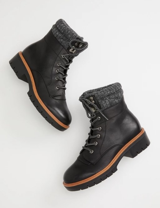 A pair of black adventure boots with lace up closure, a lightly padded footbed, and a lace collar