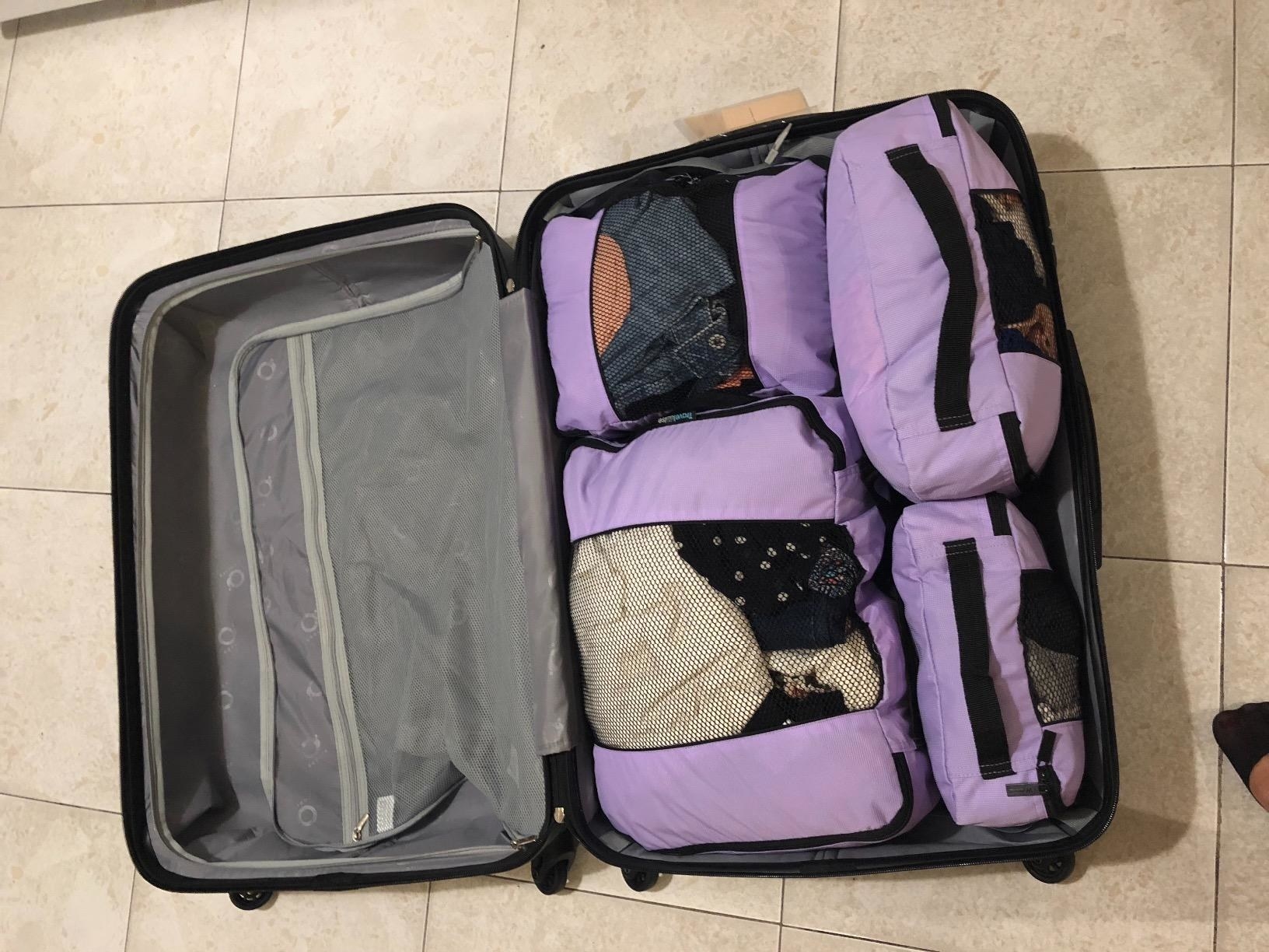 reviewer image of packed lavender packing cubes inside a suitcase