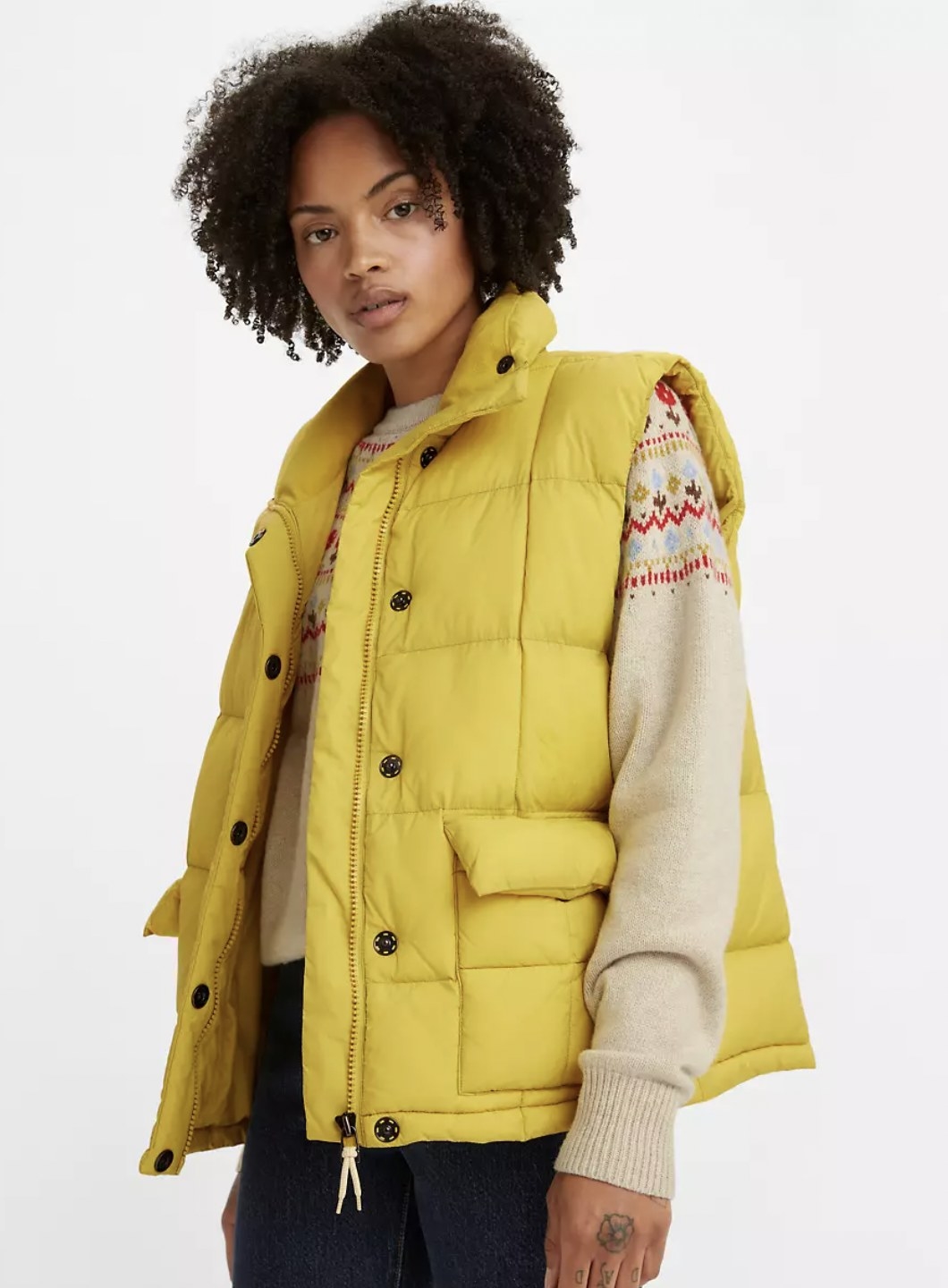 Model wearing the yellow vest over a sweater