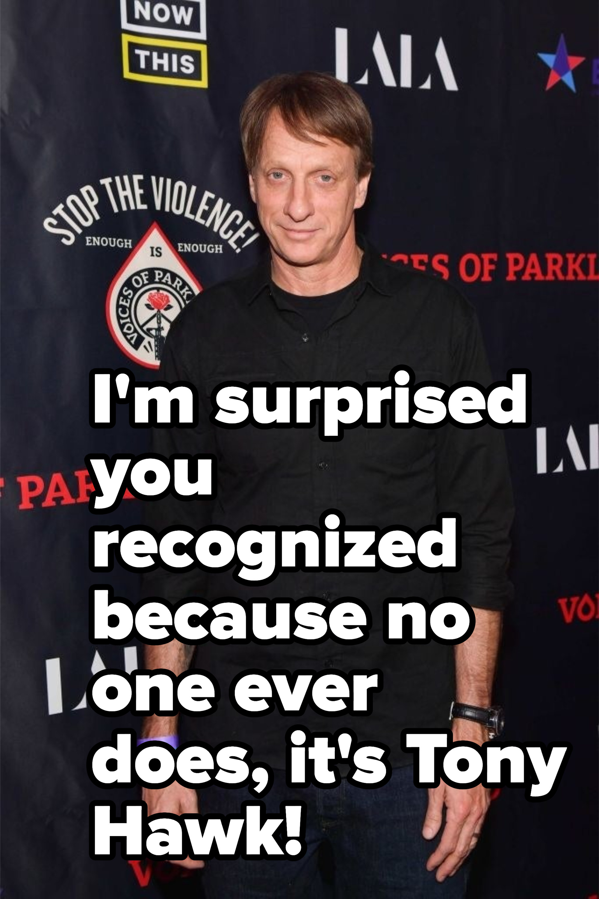 Tony hawk is in a black shirt on a red carpet