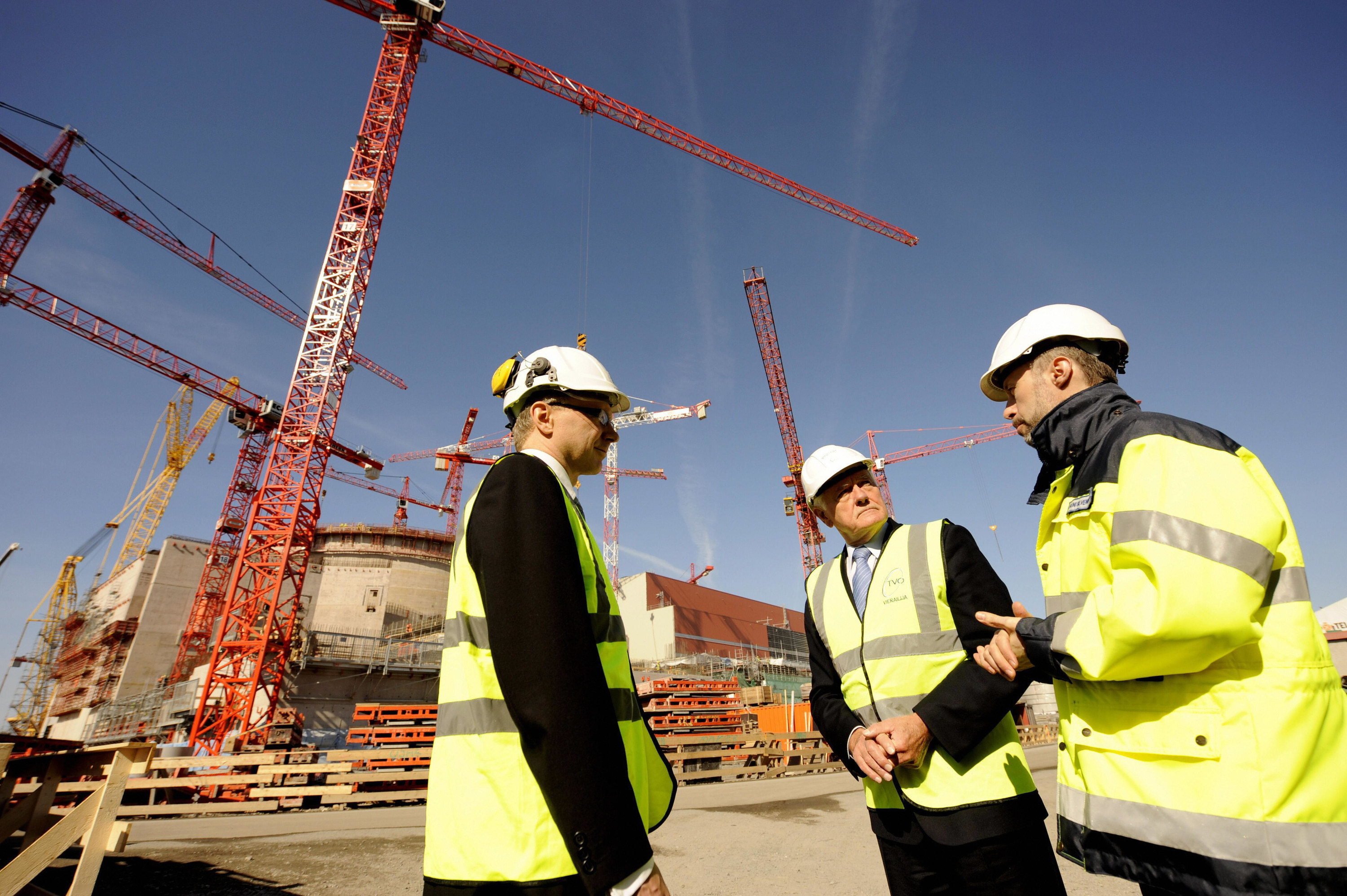 Three construction workers standing and talking together