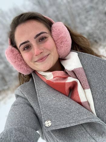 Reviewer wearing the pink earmuffs in the snow