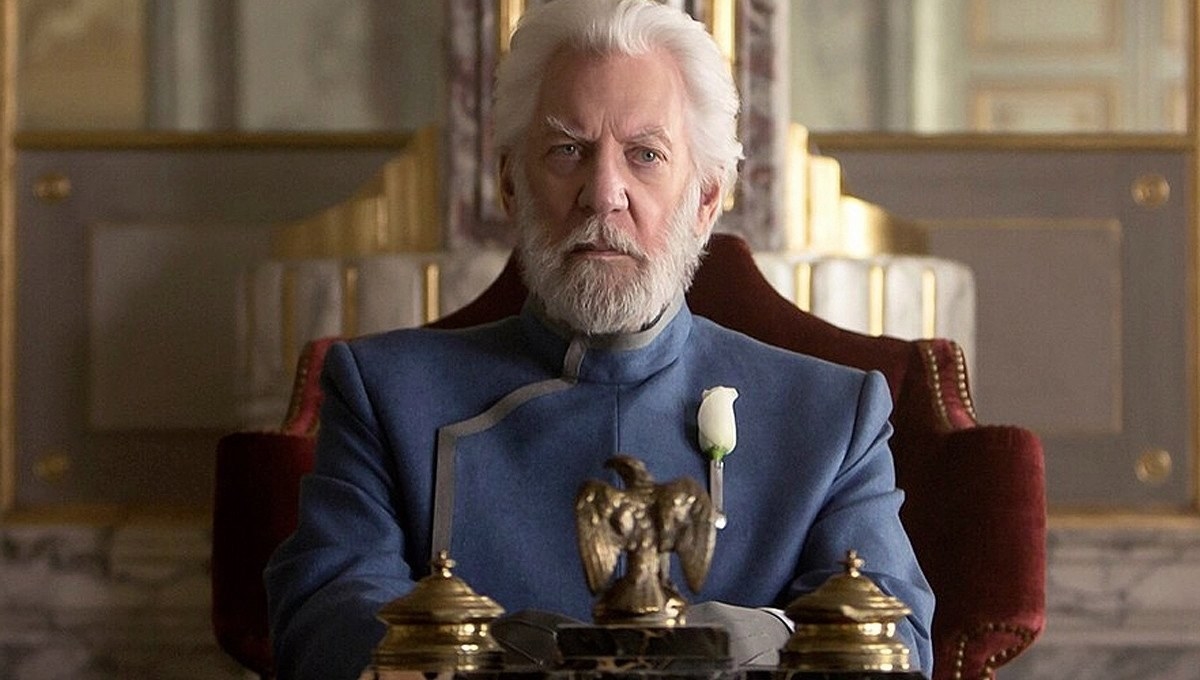 president snow sits looking regal in his throne room