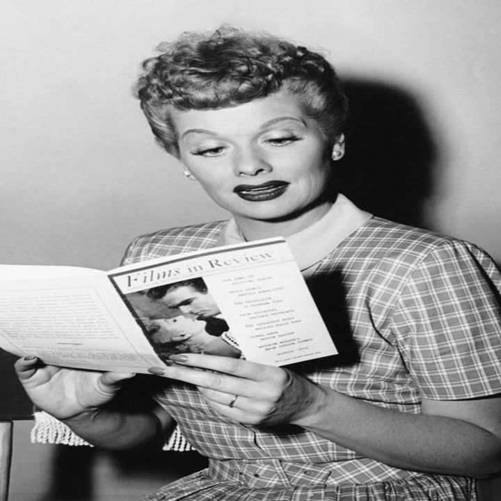 The real Lucy reading a pamphlet that says "Films in Review"