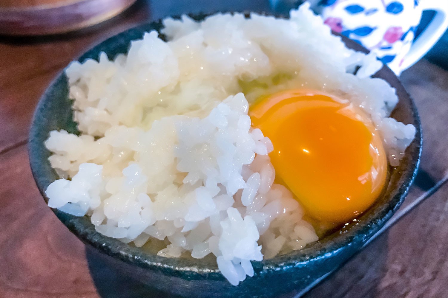 An uncooked egg over white rice.