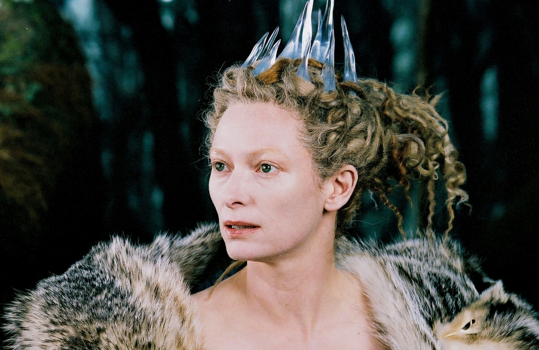the white witch looks to the side with a pretty cool ice crown on her head