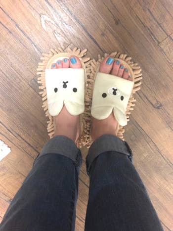 reviewer wears same white and tan mop slippers with cute bear design