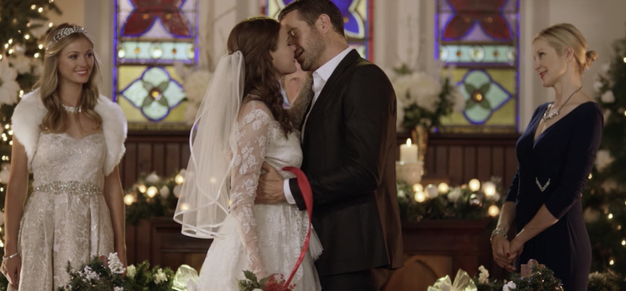 A couple stand in wedding clothes at an altar in a church, kissing. They&#x27;re watched by another woman in a bridal dress and an older woman.