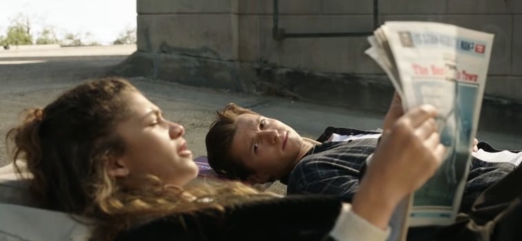 Peter lying on a rooftop with MJ, who is reading a newspaper, in &quot;Spider-Man: No Way Home&quot;