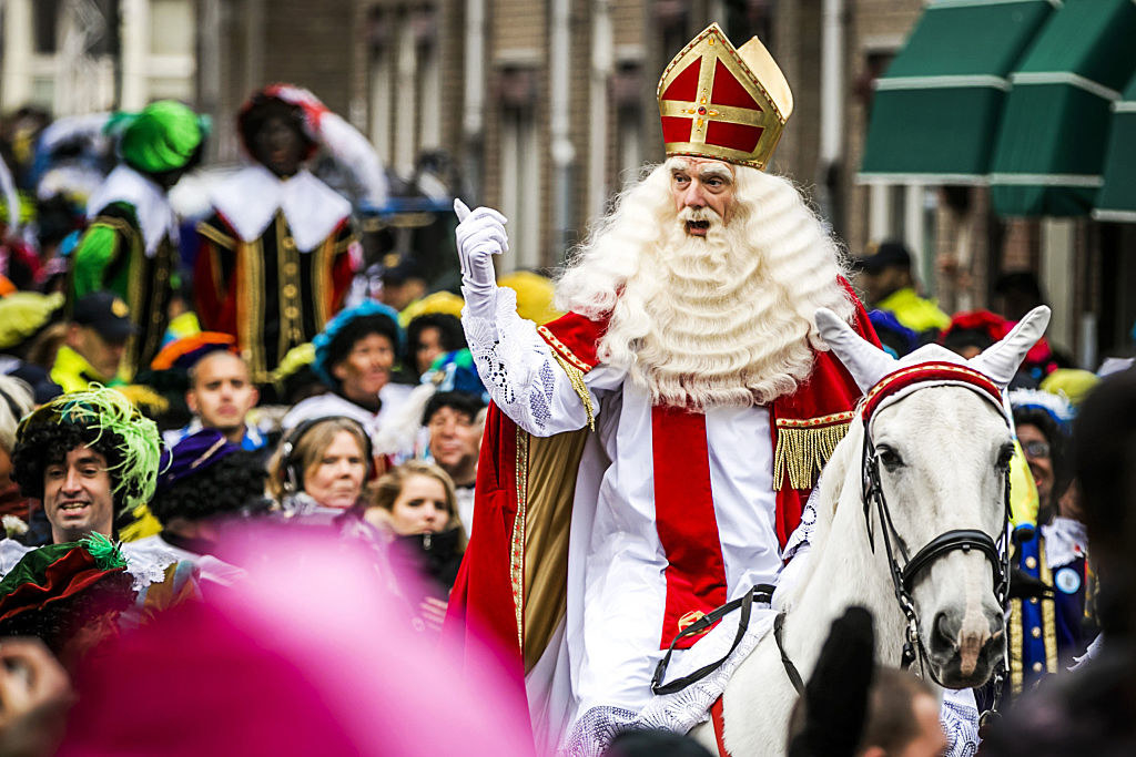 Sinterklaas riding a horse through the crowded streets