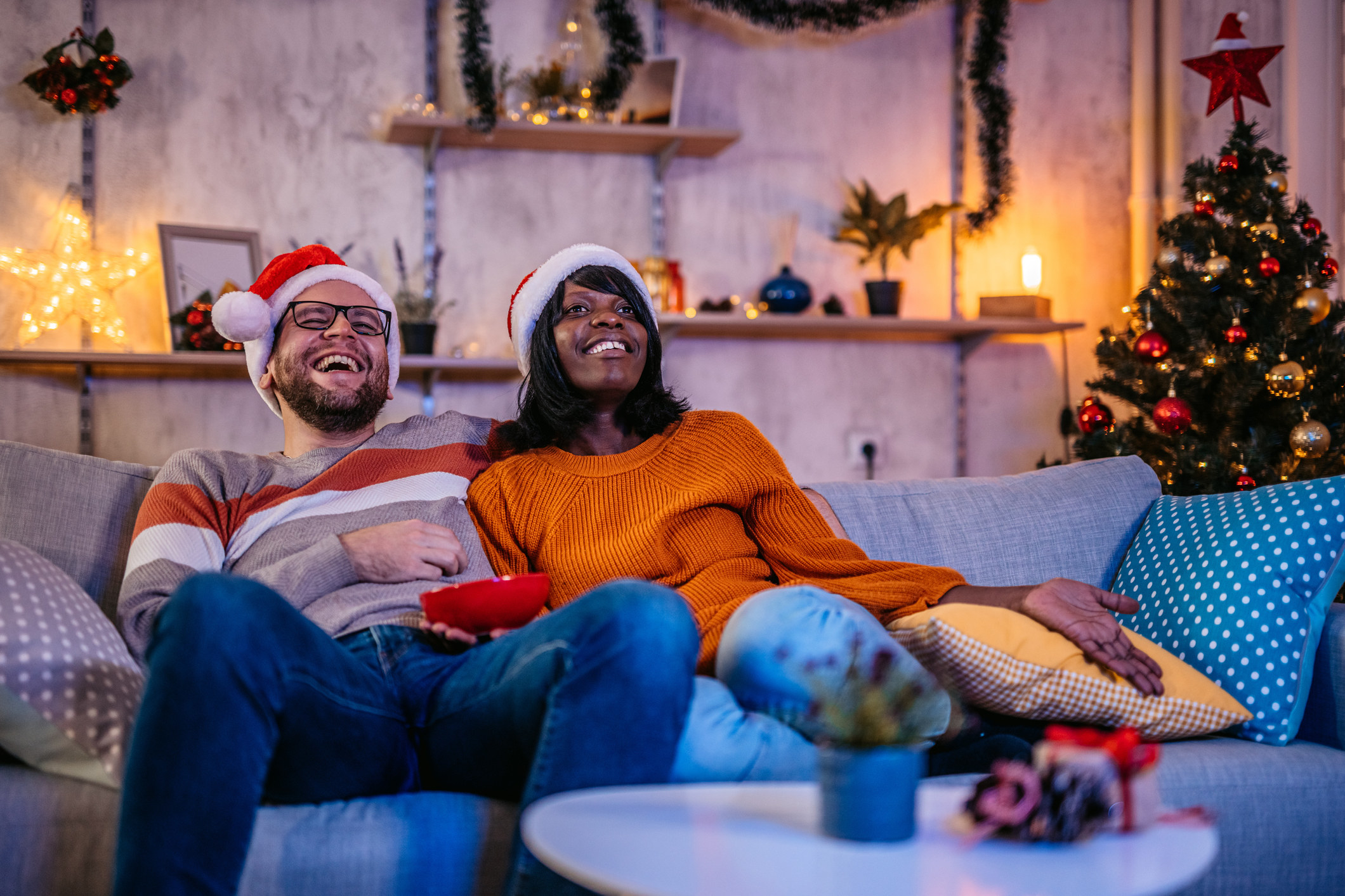 A couple watching Christmas movies and laughing