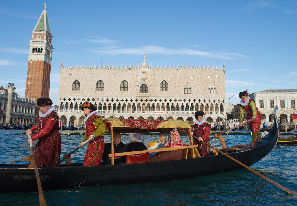 Gondoliers dressed in 16th-century costumes perform a live Nativity scene while ferrying passengers in gondolas from St Mark&#x27;s to the Island of San Giorgio