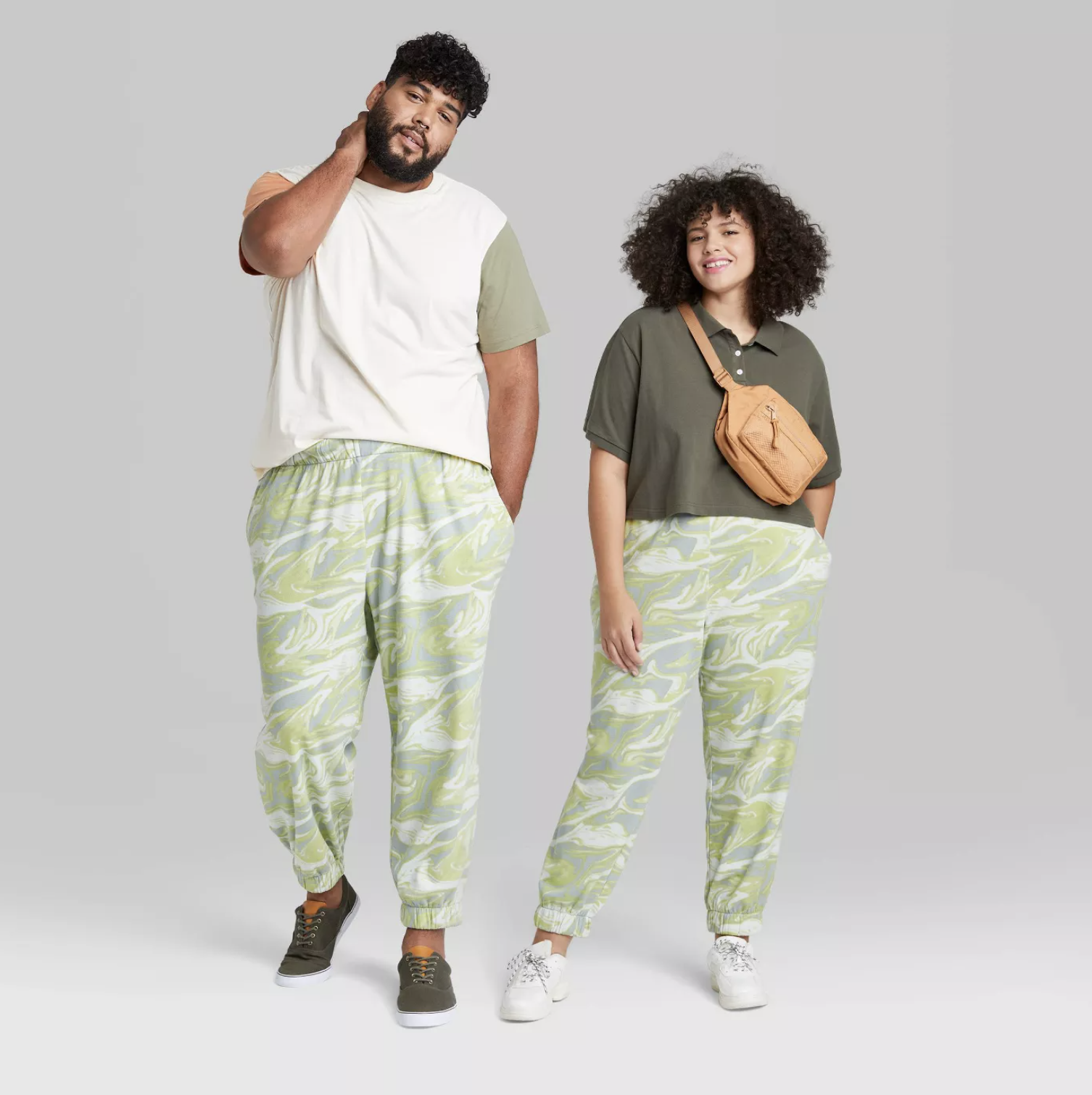 two models wearing the joggers in light green swirl pattern