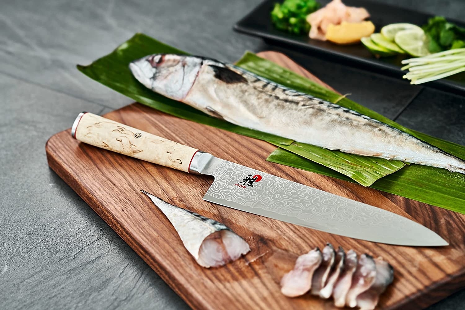The Miyabi knife on a cutting board next to fish