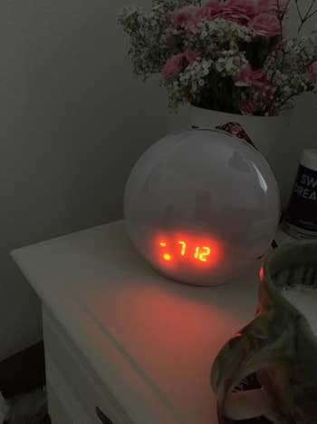 Reviewer photo of the lamp turned off, only illuminated by the digital clock