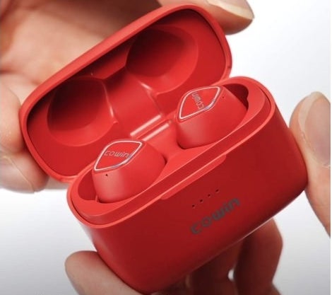 Model holding red charging case with wireless earbuds inside