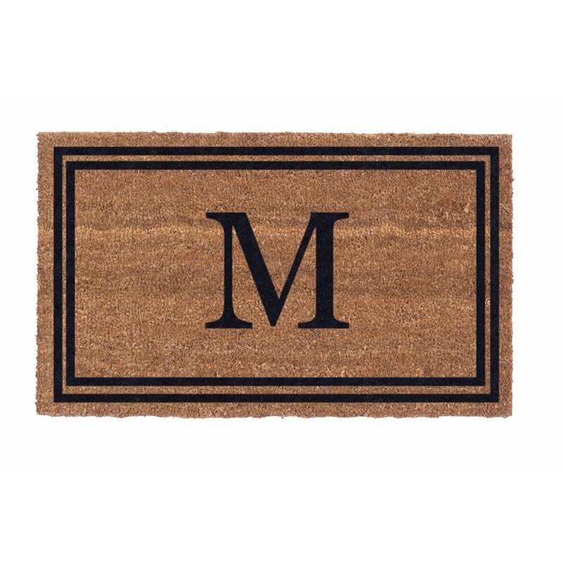 A photo of an outdoor rug with a M