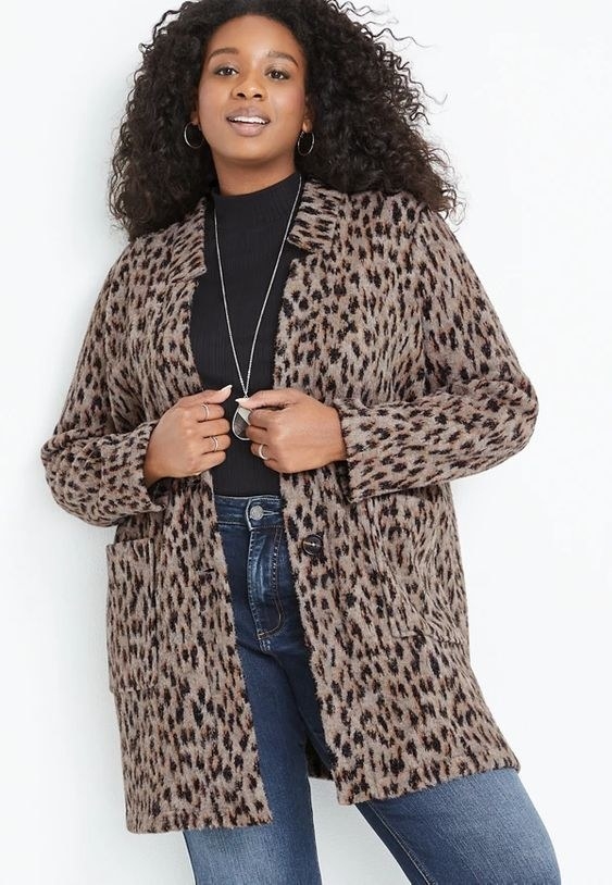 An image of a model wearing a plus size leopard cozy cardigan