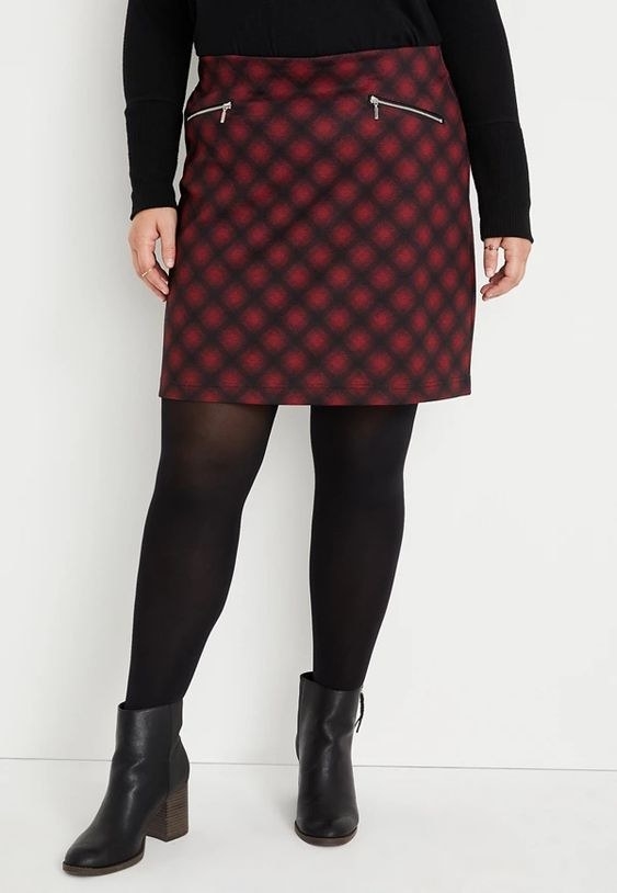 An image of a model wearing a plus size red buffalo plaid Ponte skirt
