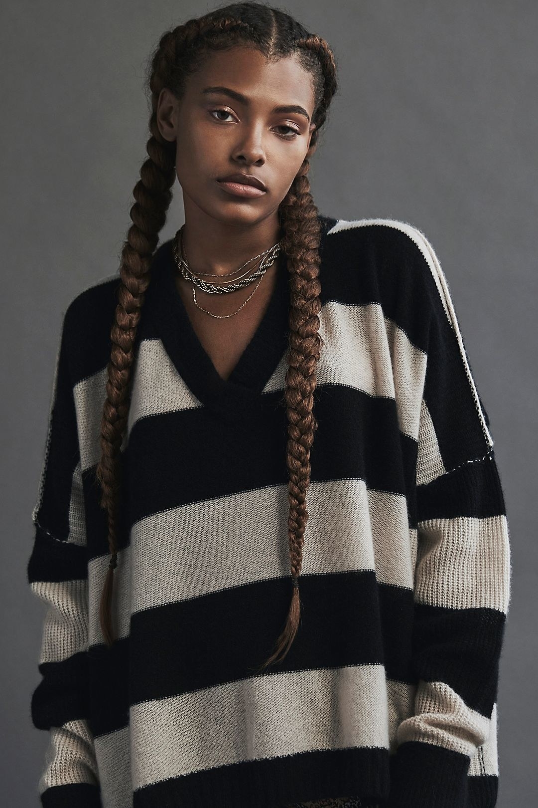 a model wearing the tunic in black and oatmeal