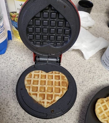 a reviewer making a heart shaped waffle in the waffle iron