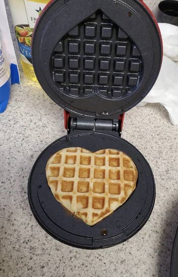 a reviewer making a heart shaped waffle in the waffle iron