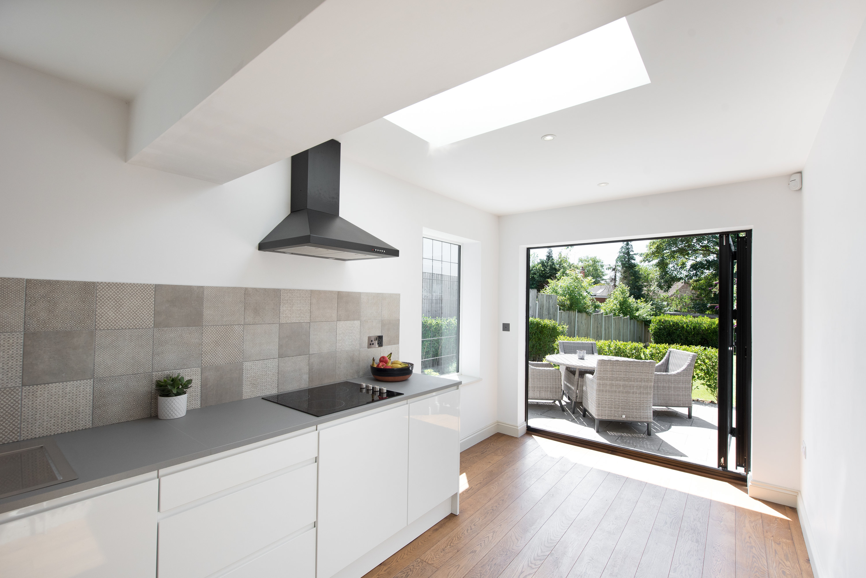 Large skylight over a modern, gray and white kitchen.
