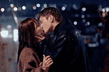a man and woman kiss in the rain