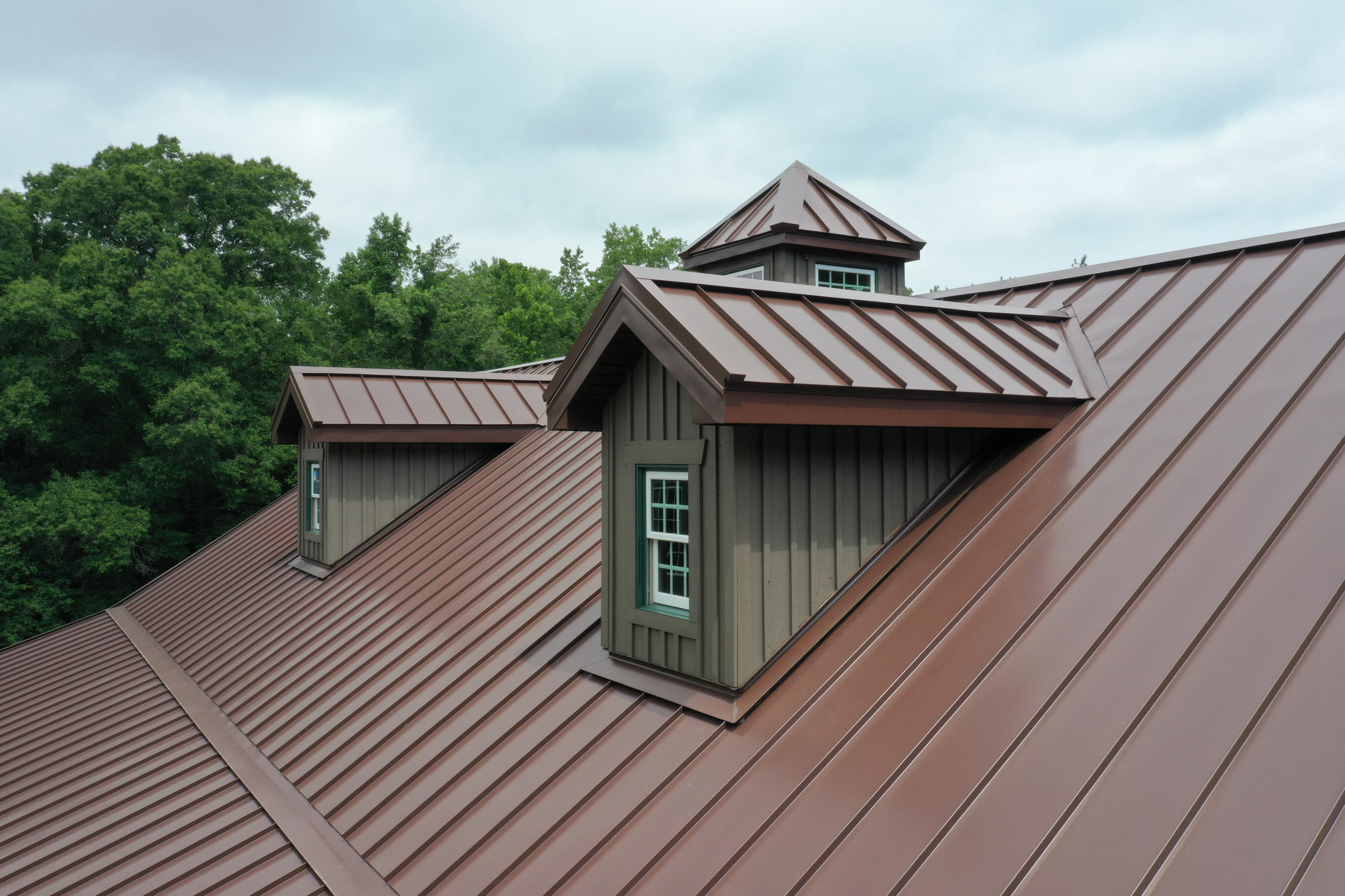 Rust-colored metal roof on a large house