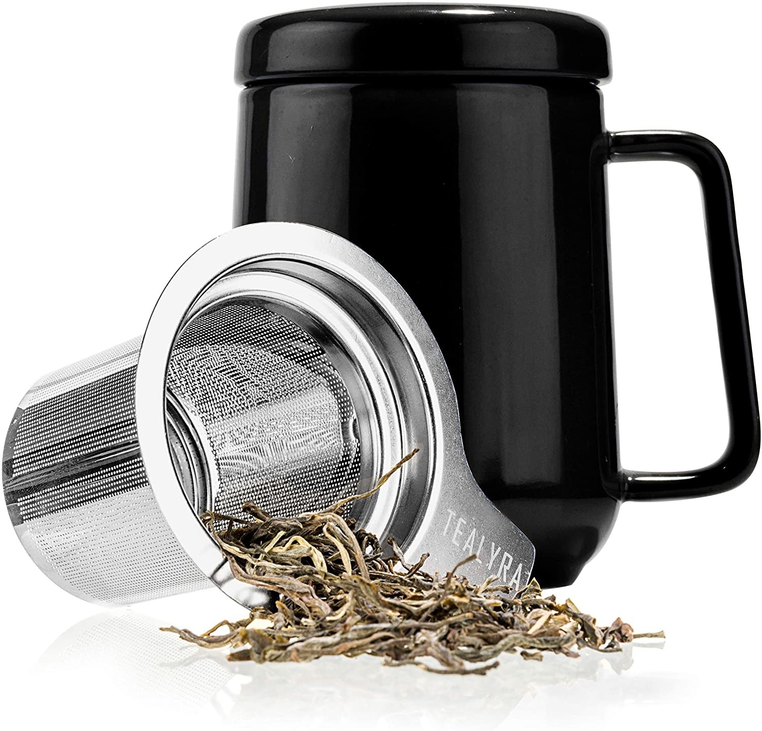 A ceramic mug with a handle and a steel tea infuser with tea leaves spilling out of it