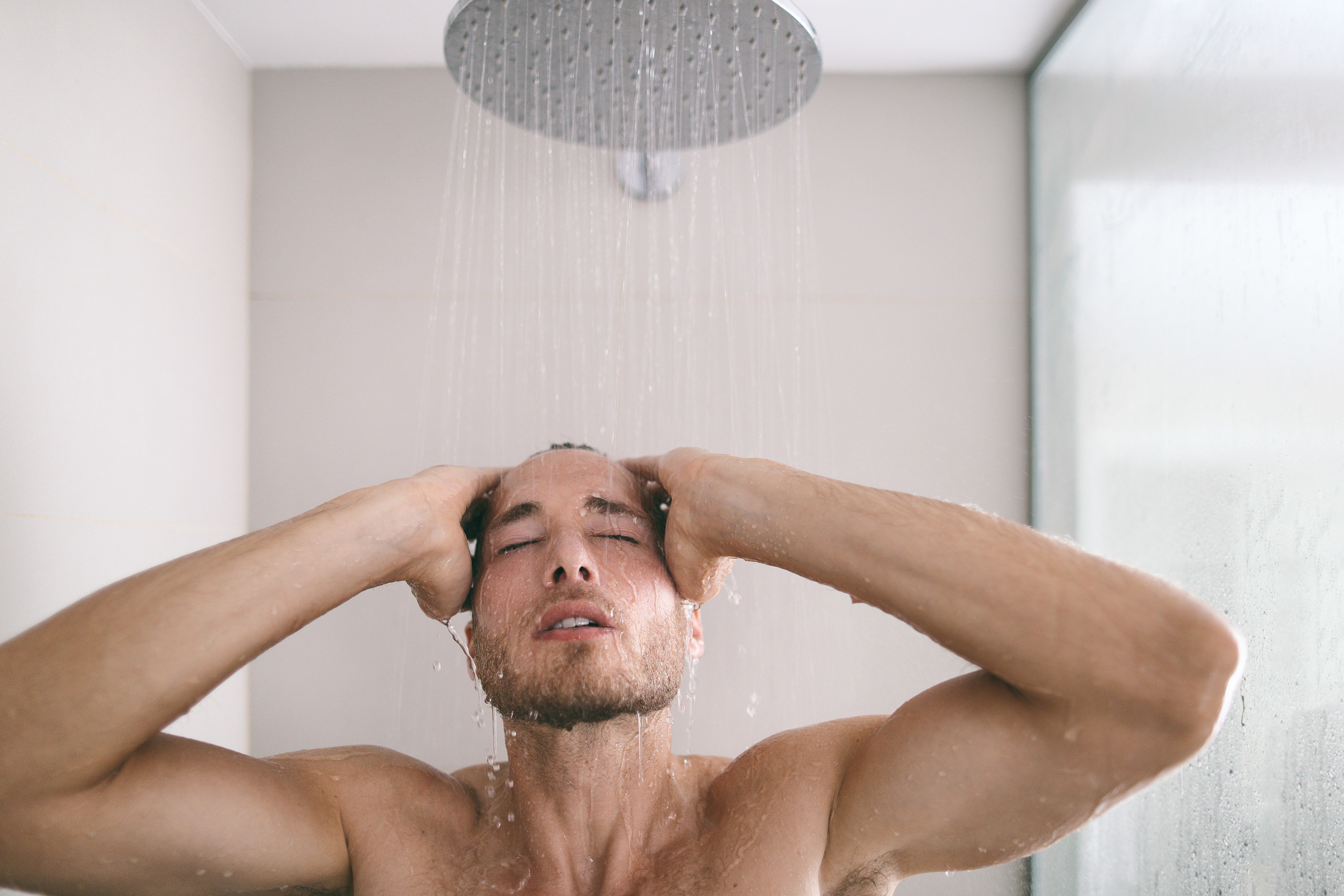 Person taking a shower under a very wide showerhead