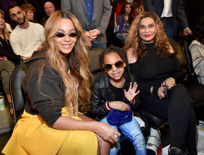 Beyonce, Blue Ivy Carter, and Tina Knowles-Lawson sit side-by-side while Blue Ivy waves at the camera