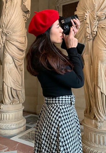Reviewer wearing the red beret while taking a photo