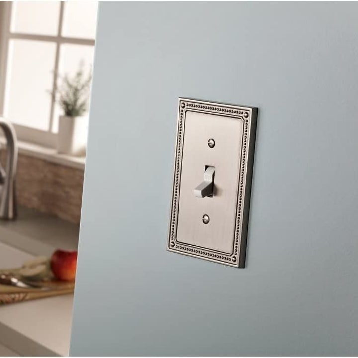 reviewer image of the satin nickel switch plate over a single switch