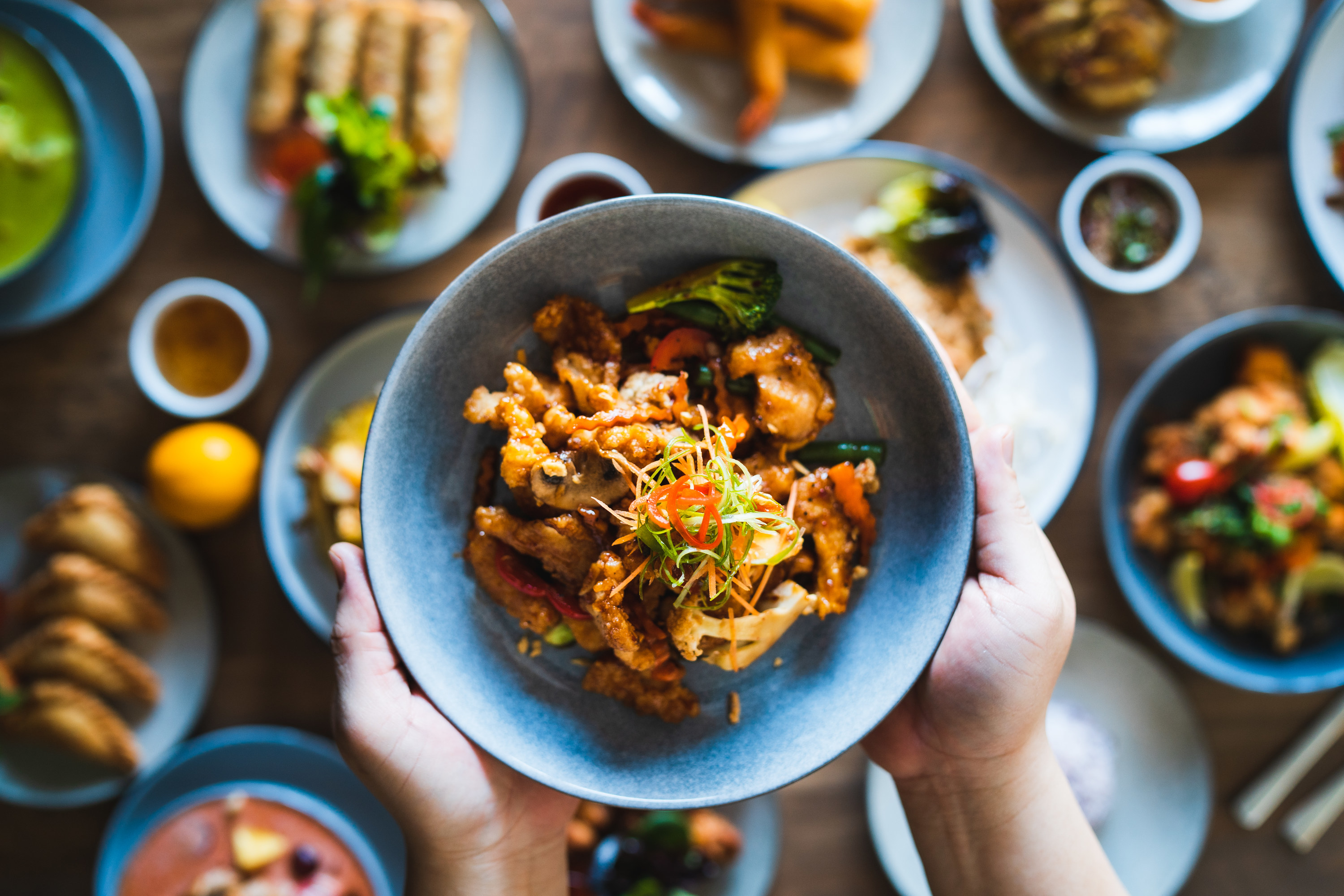 A person holding a bowl with a Thai dish inside called &quot;Pak Krapao Moo&quot;